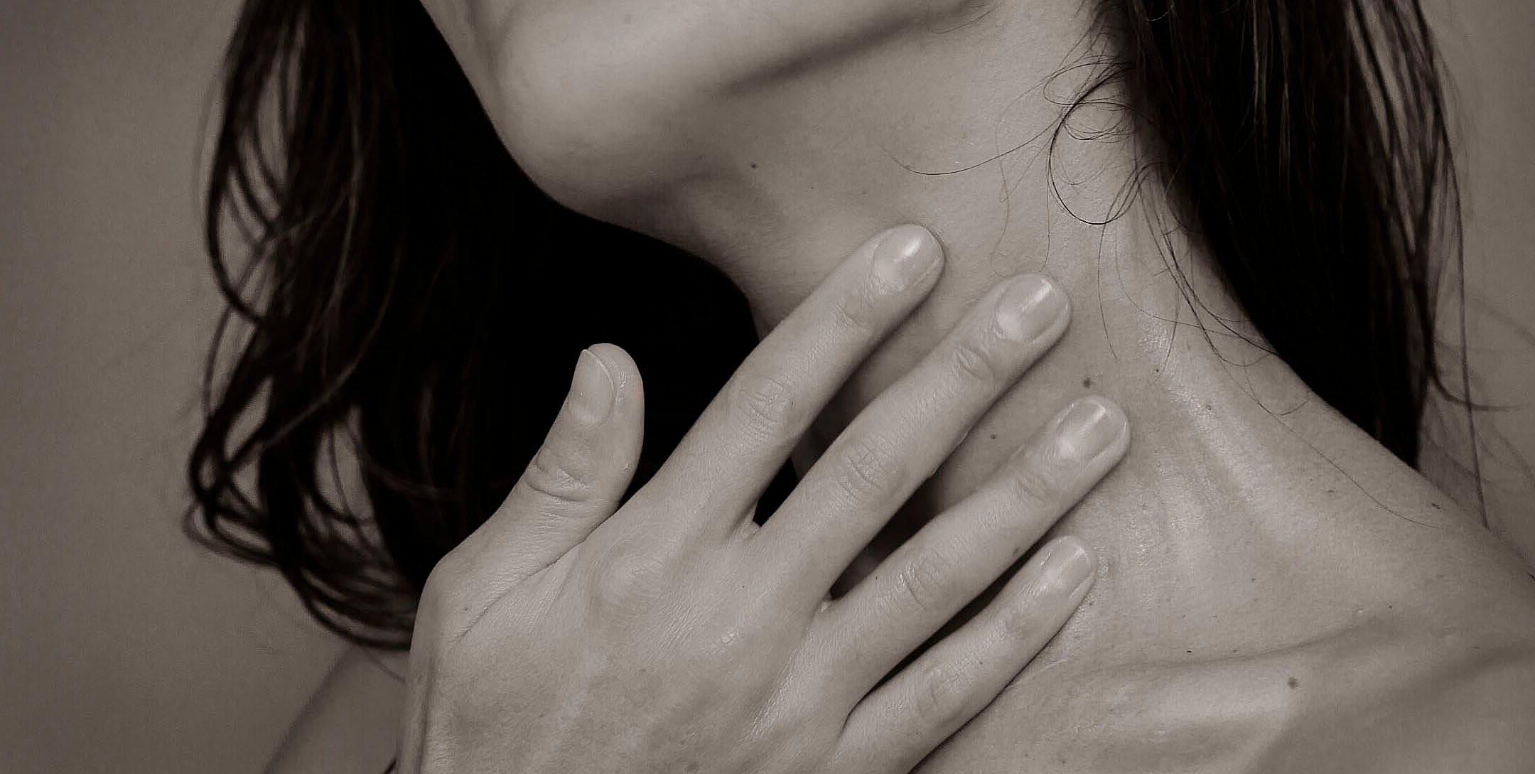 woman's neck with hand in black and white