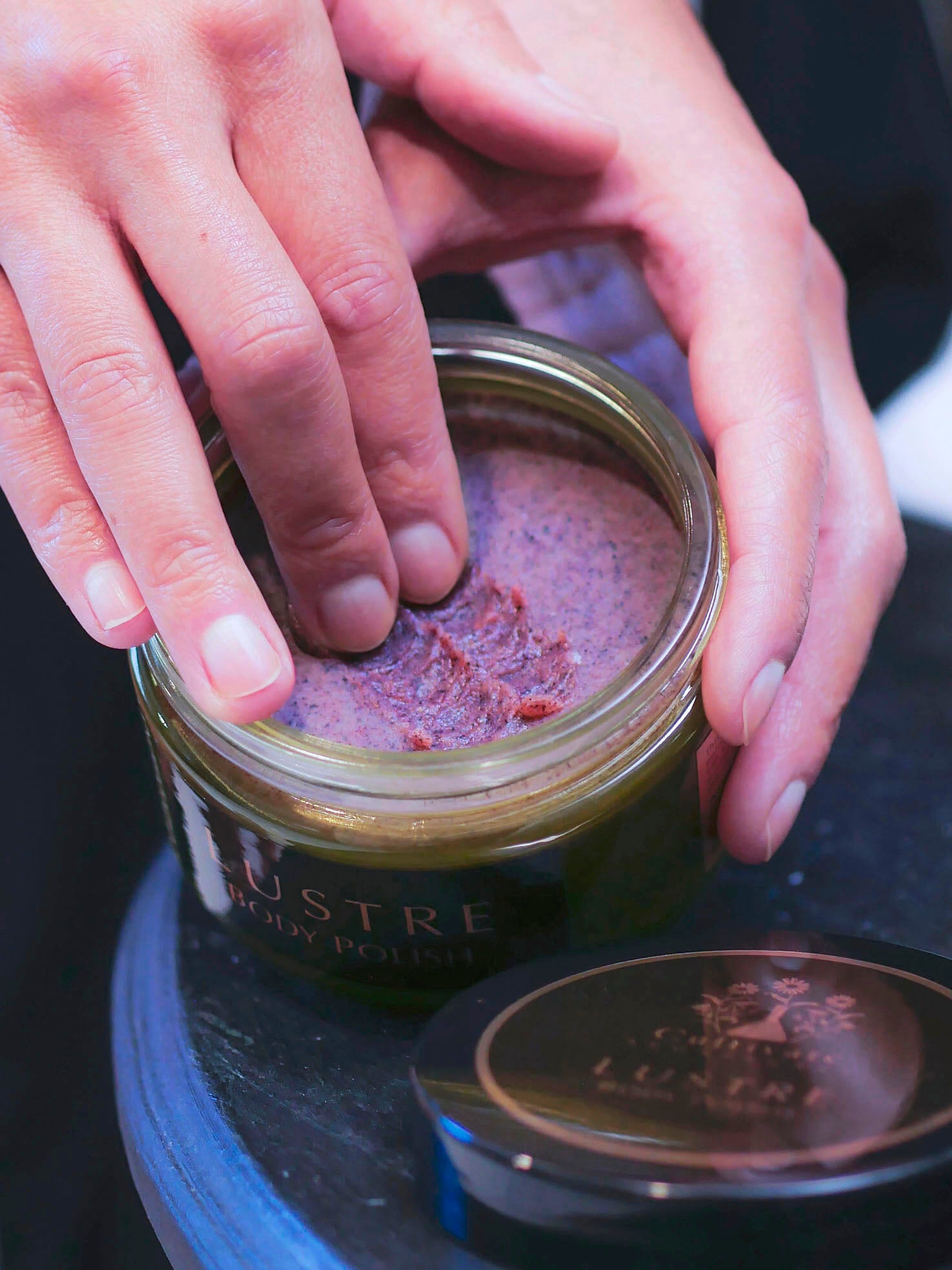 body scrub in jar with fingers