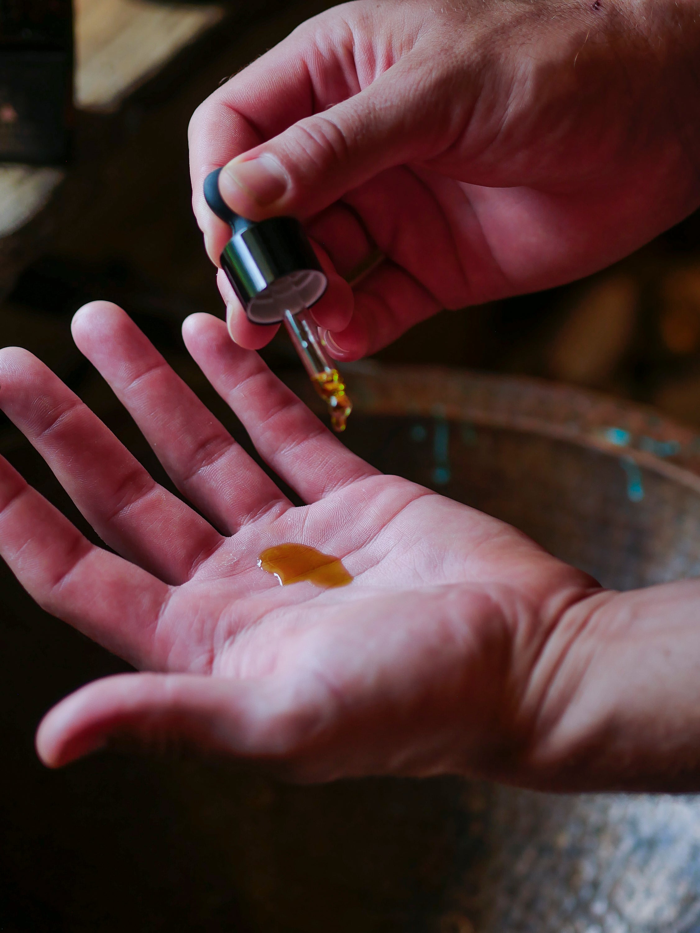 hands with dropper holding a face serum