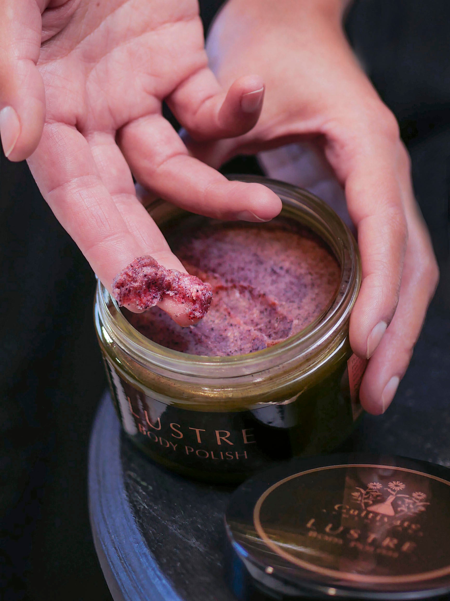 body scrub by Cultivate in jar with fingers